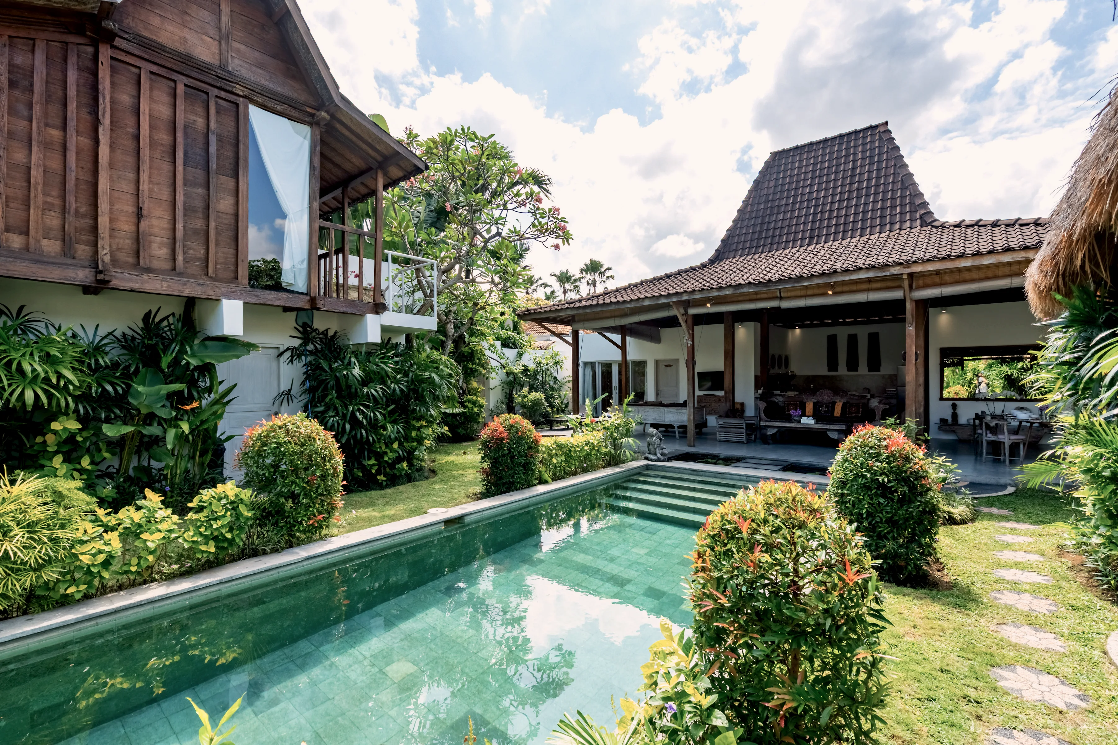 The pool running the length of the house, clipped shrubs at the edge