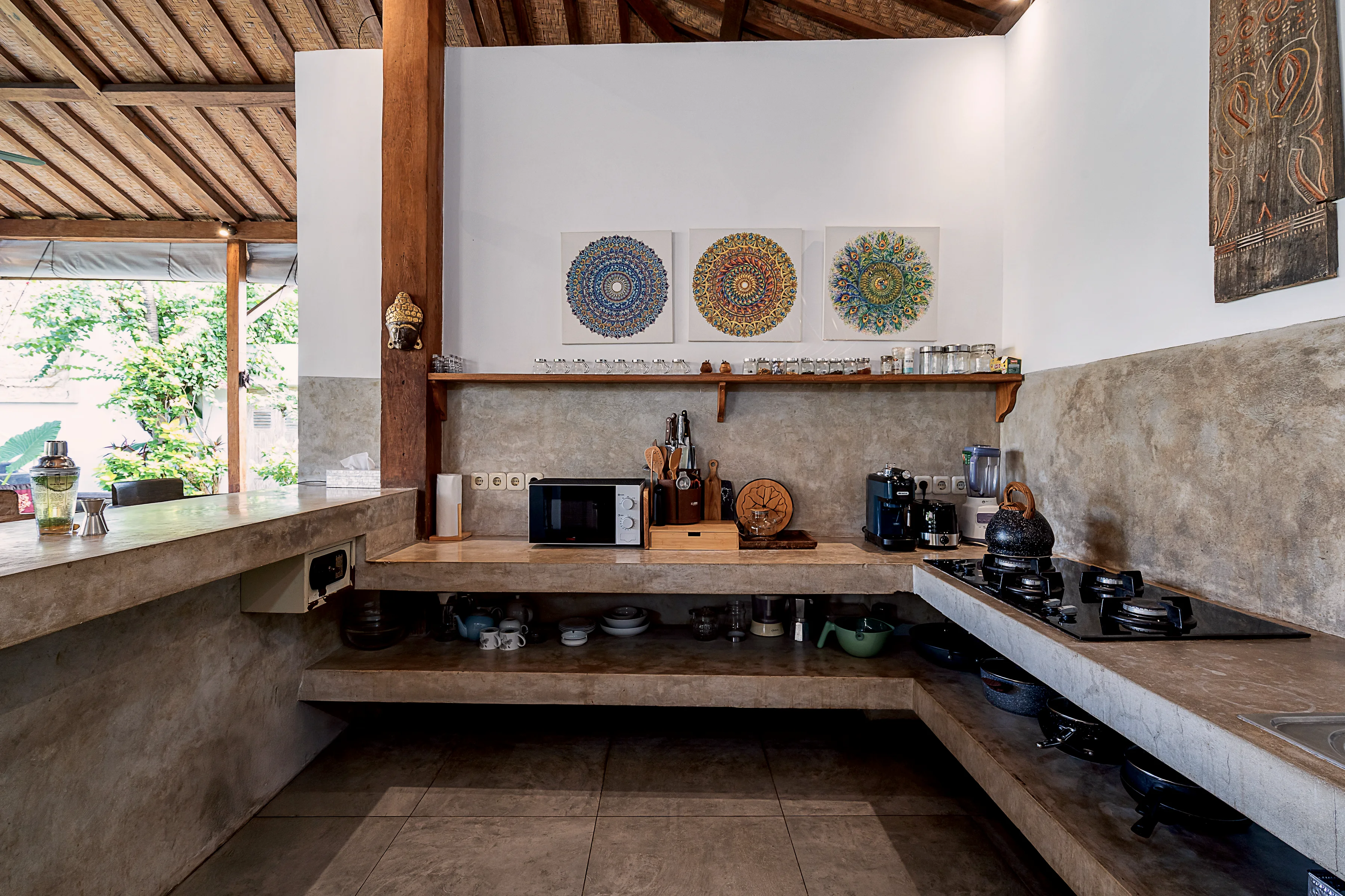 The kitchen counter with a gas hob, a sink and carved panels above