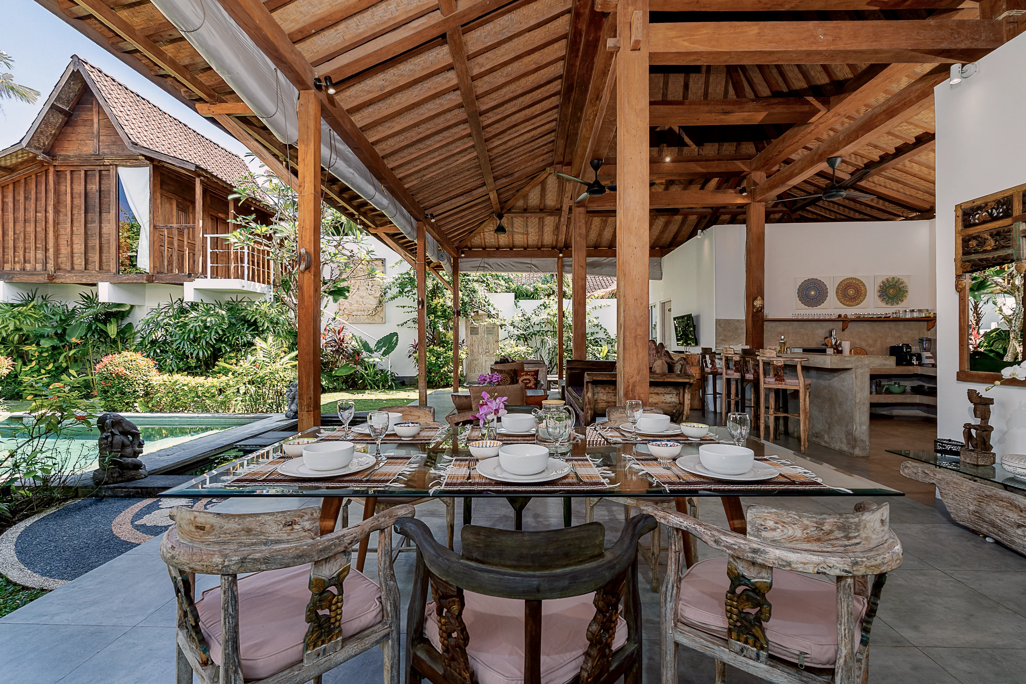 The long table set for dinner under the pavilion roof, the garden beyond