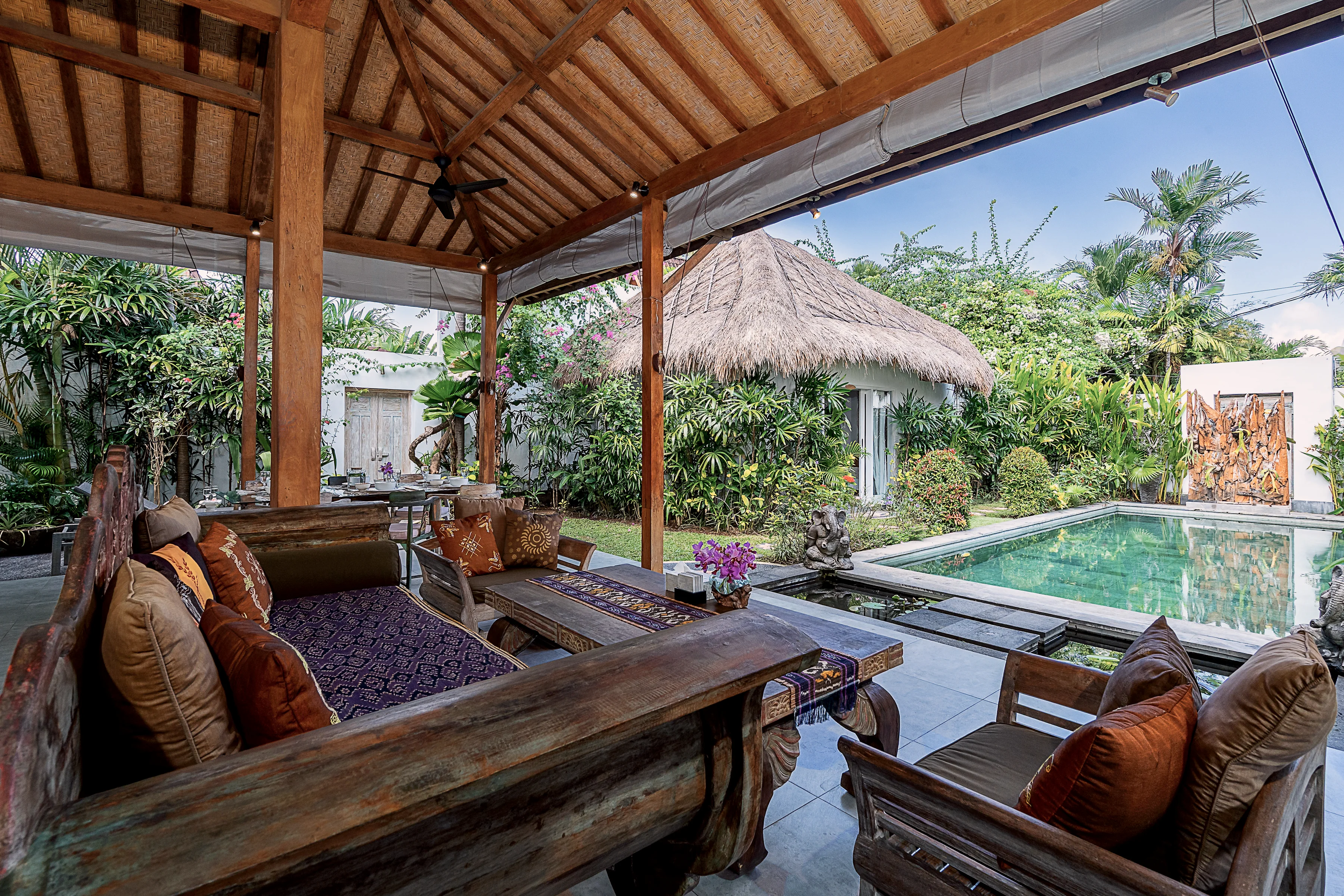 A daybed with batik cushions looking out to the pool
