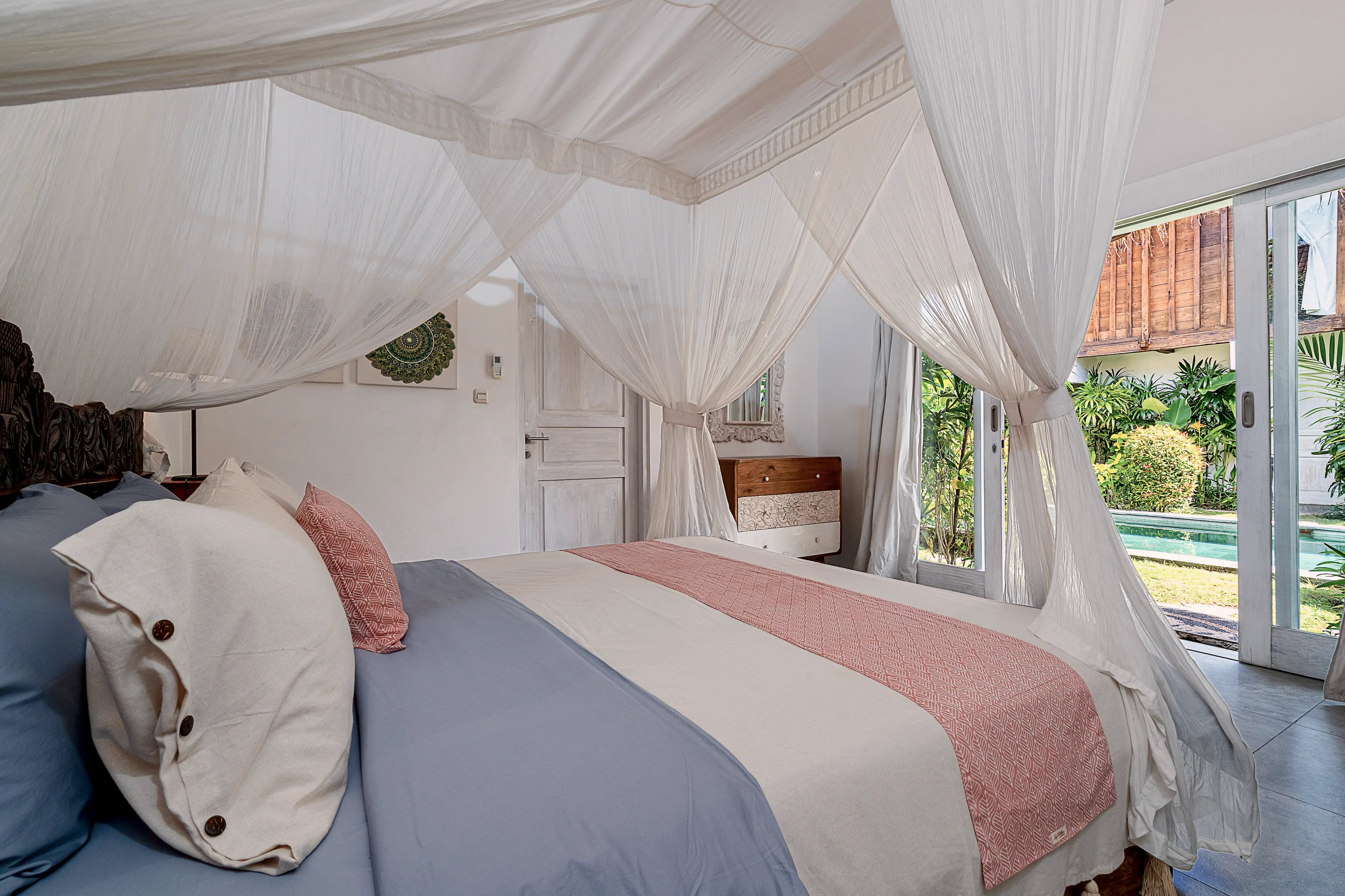 Pink and grey linen on the master bed, the garden doors beyond