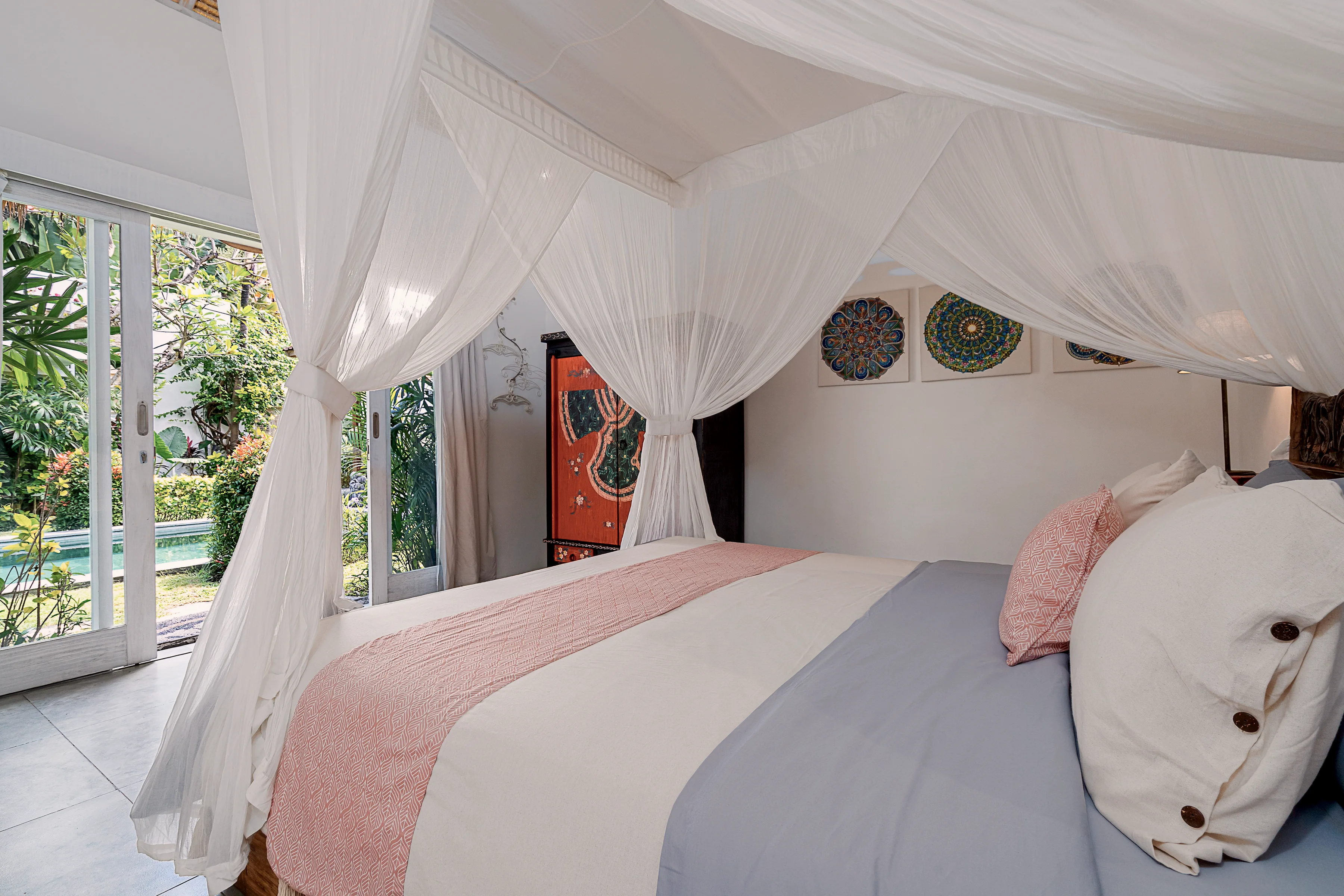 The master bed under netting, by the doors to the garden