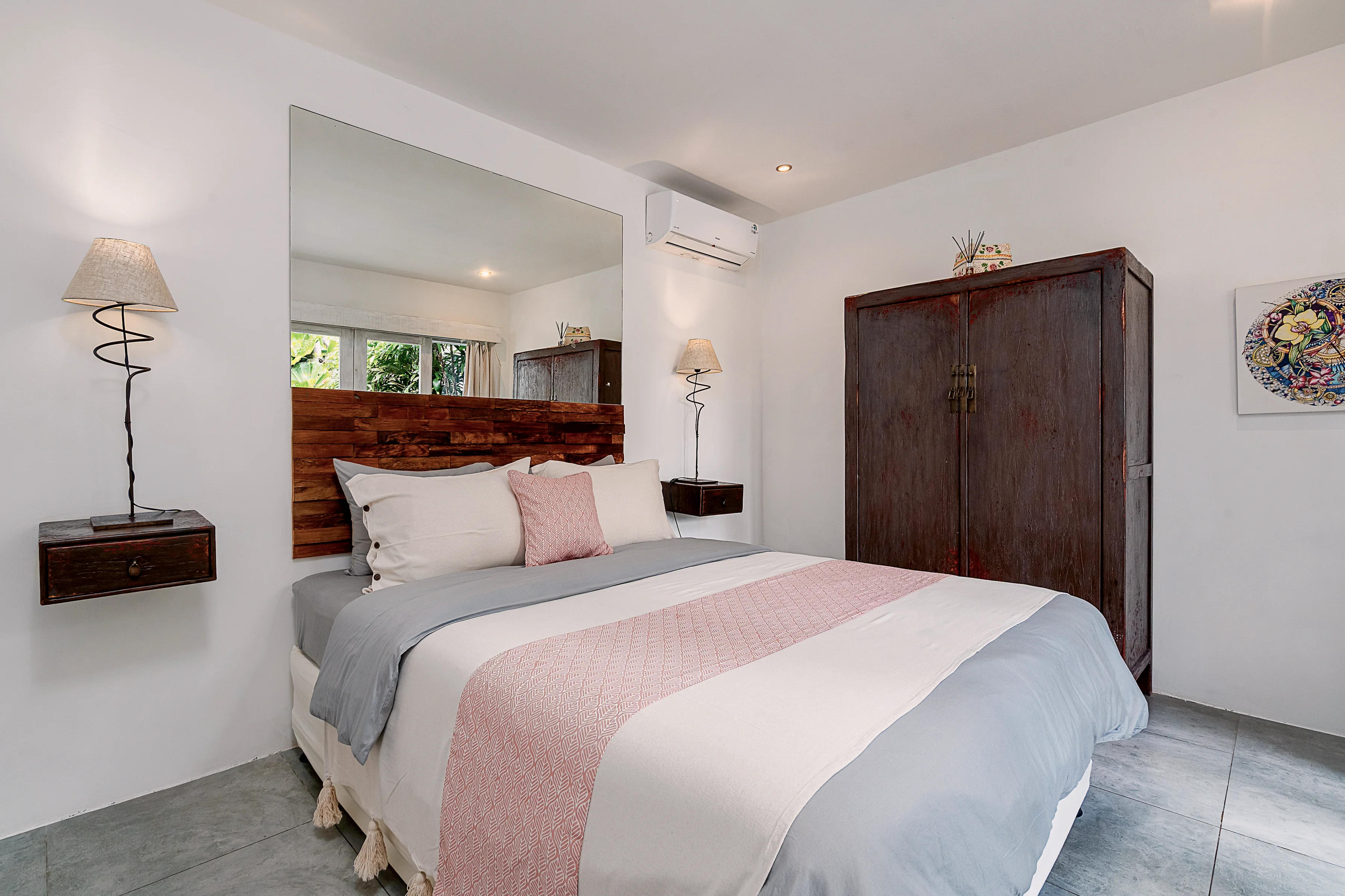 A garden bedroom with a dark wooden wardrobe and bedside lamps