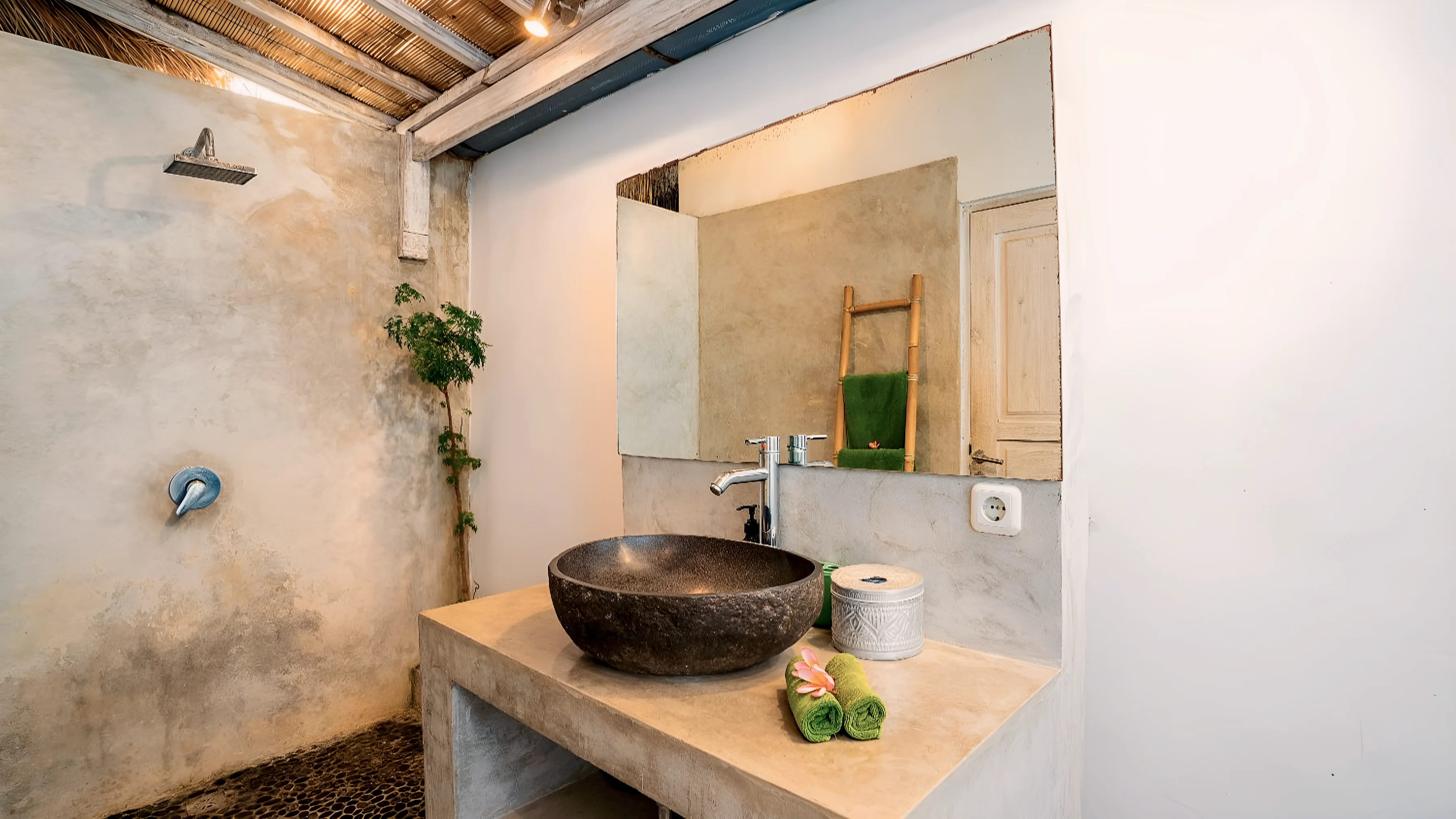 A bathroom with a stone basin, a shower and a towel ladder