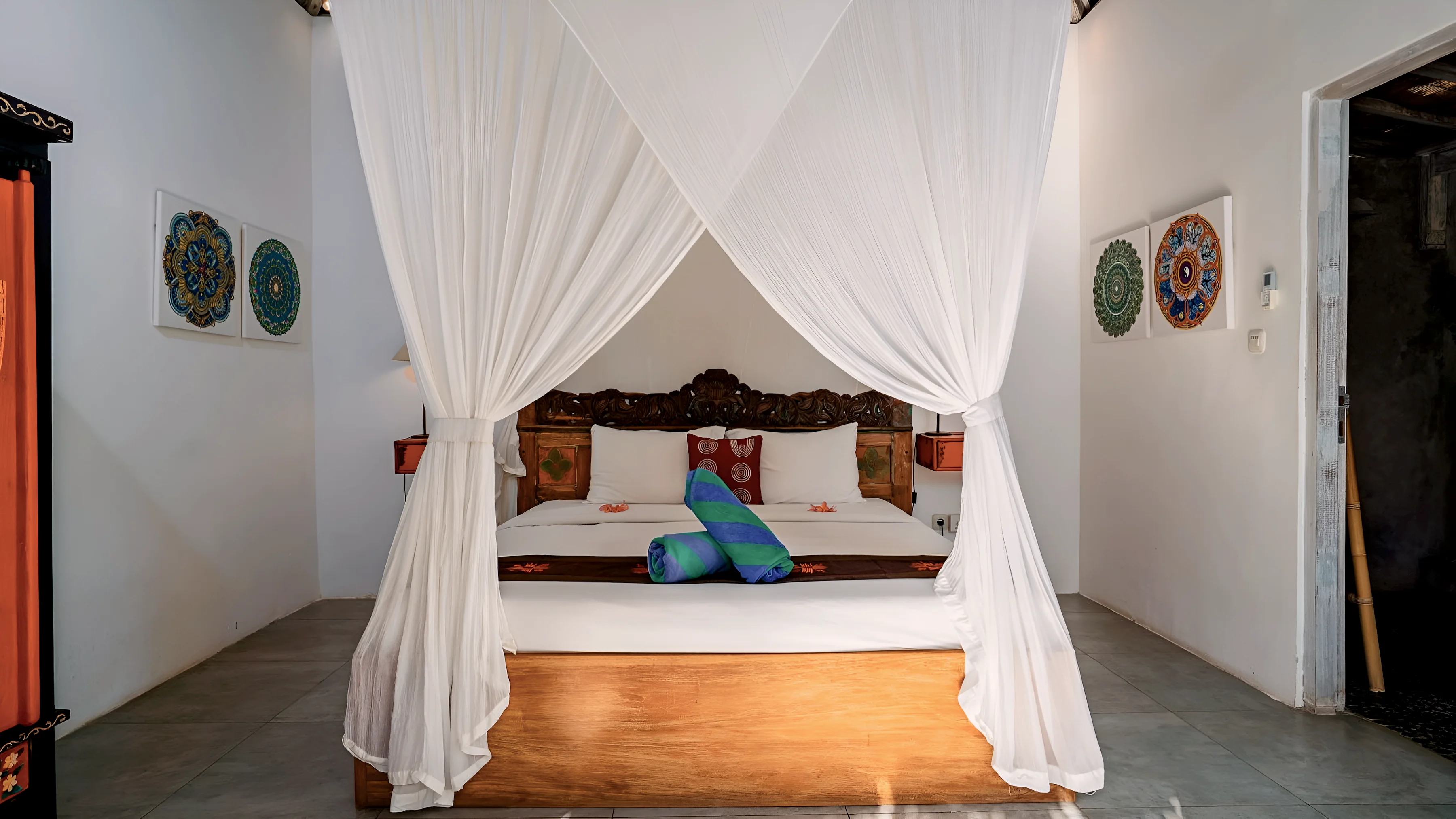 A four-poster bed with white netting drawn open