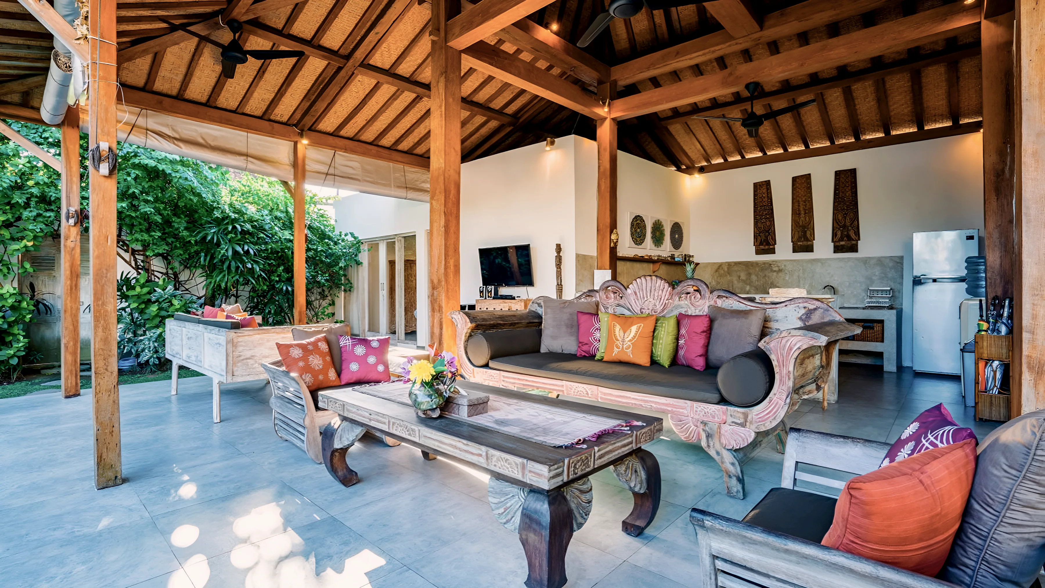 The living pavilion by day: carved daybeds, cushions and low tables